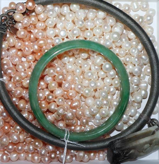 Two cultured pearl opera length necklaces (white and champagne), a green jade bangle and a jade pendant